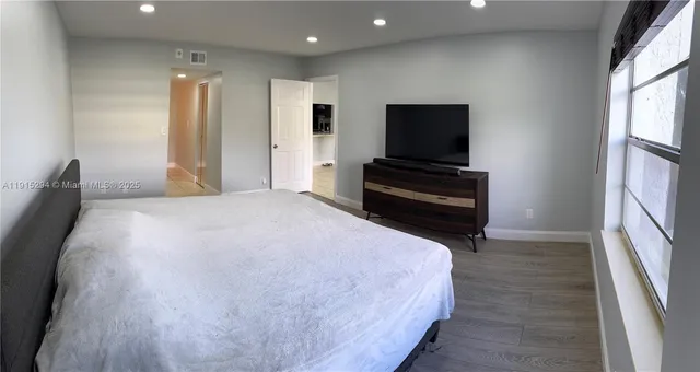 a bedroom with a bed and wooden floor