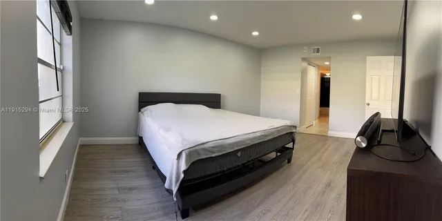 a bed sitting in a spacious bedroom next to a window