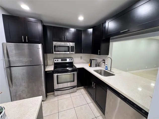 a kitchen with stainless steel appliances a refrigerator sink and microwave