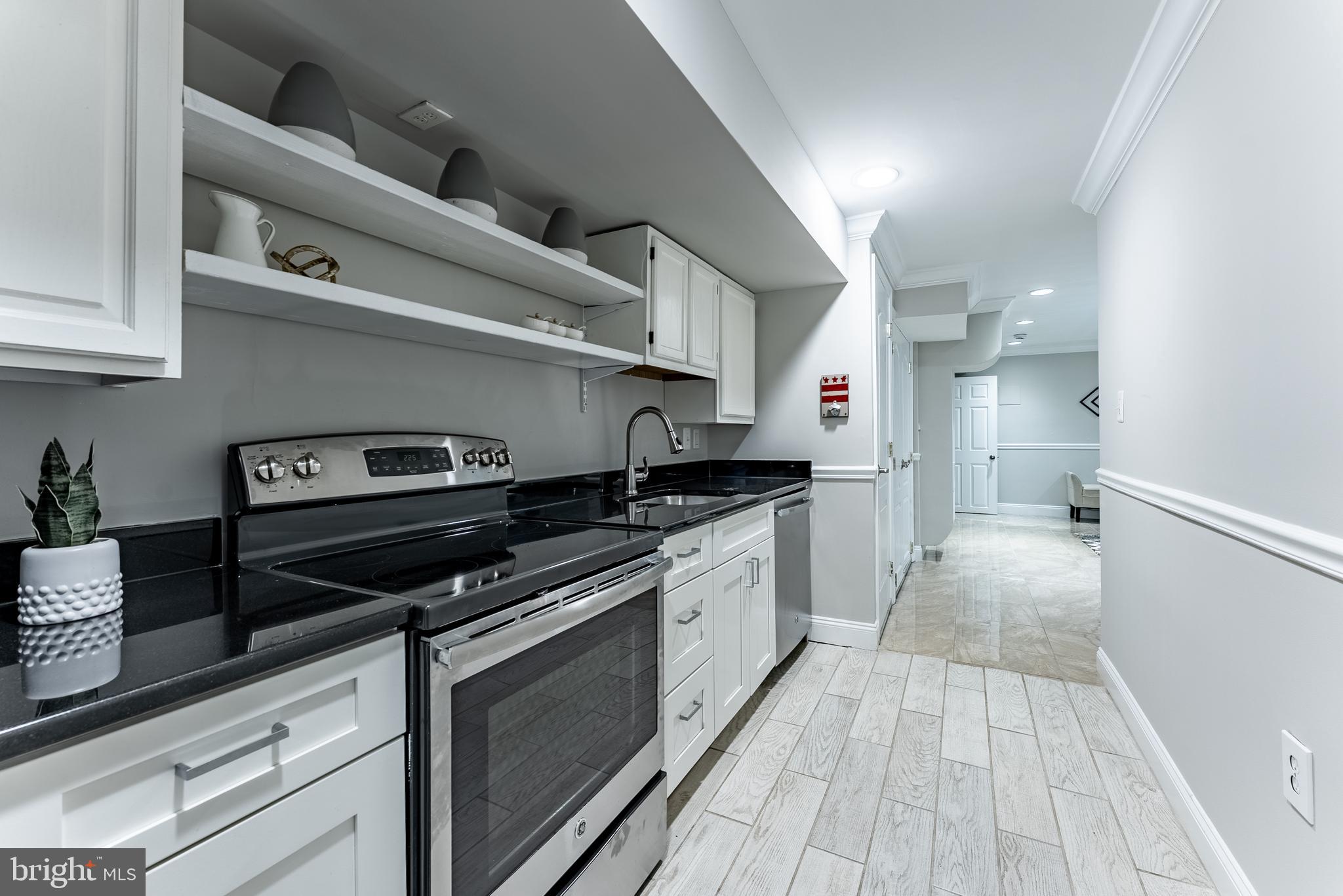 1840 D Street Northeast, Unit 1 Washington, DC 20002 - Photo 11 of 40 a kitchen with granite countertop a stove and a sink