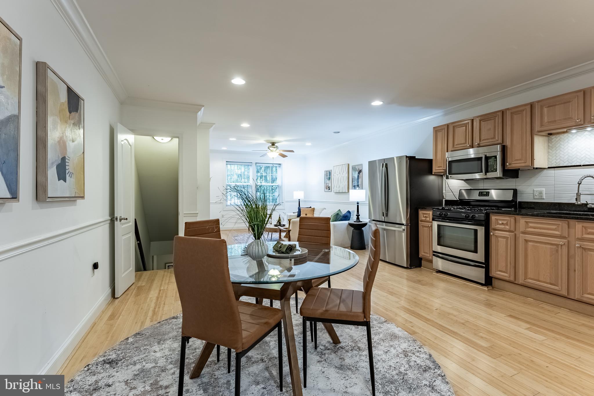 1840 D Street Northeast, Unit 1 Washington, DC 20002 - Photo 12 of 40 a kitchen with a dining table chairs refrigerator and microwave