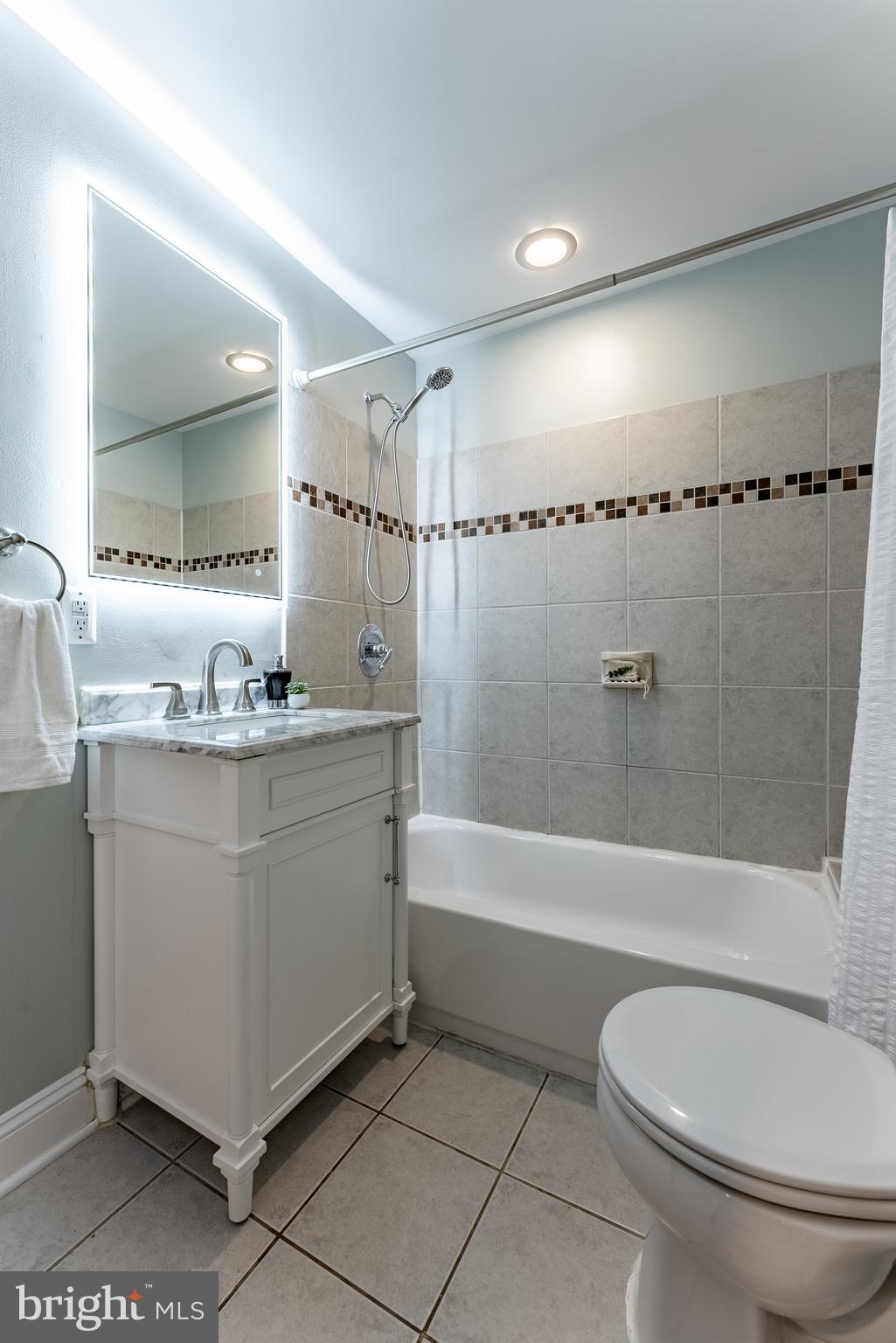 1840 D Street Northeast, Unit 1 Washington, DC 20002 - Photo 23 of 40 a bathroom with a granite countertop sink mirror vanity and toilet