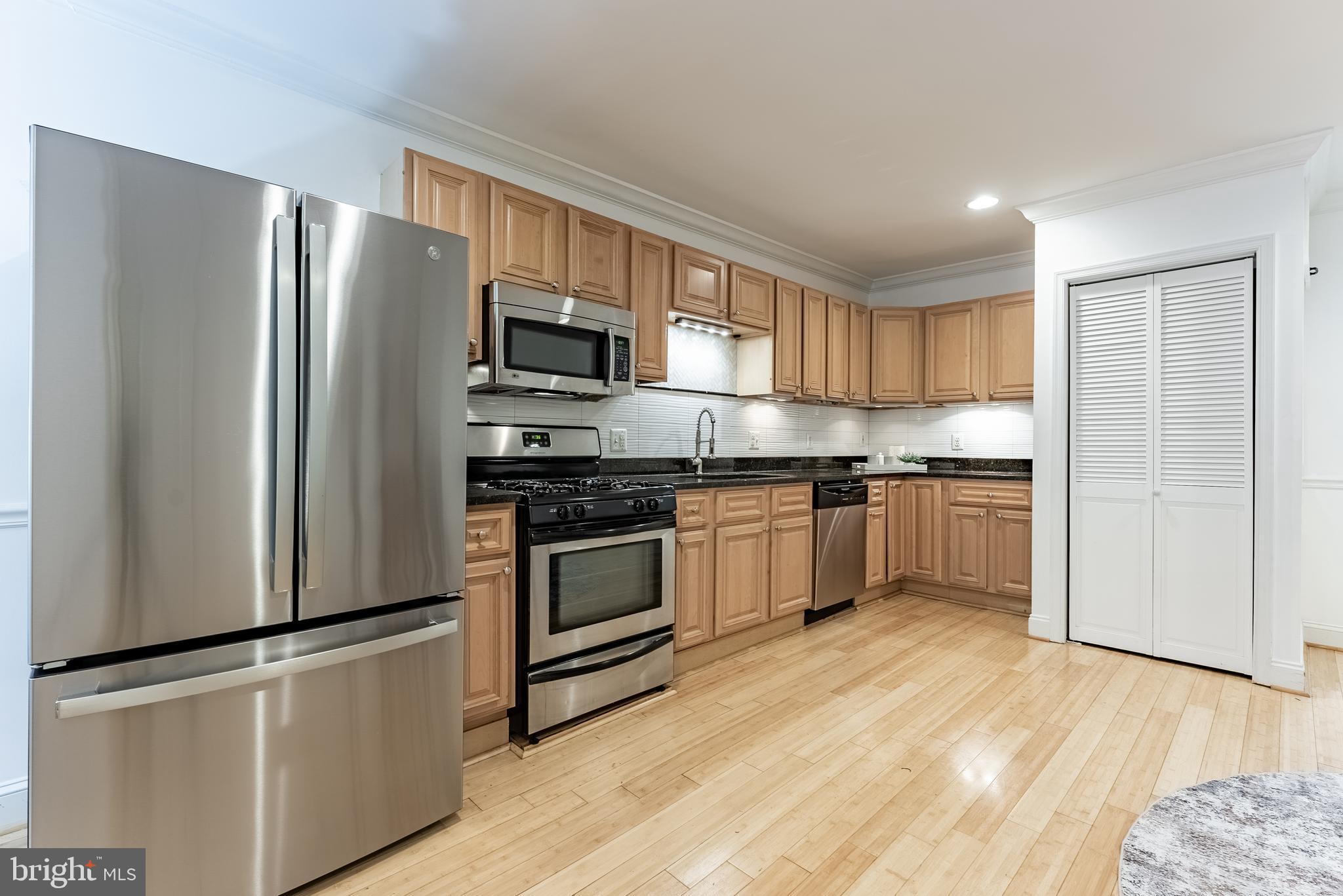 1840 D Street Northeast, Unit 1 Washington, DC 20002 - Photo 5 of 40 a kitchen with granite countertop a refrigerator stove top oven and sink