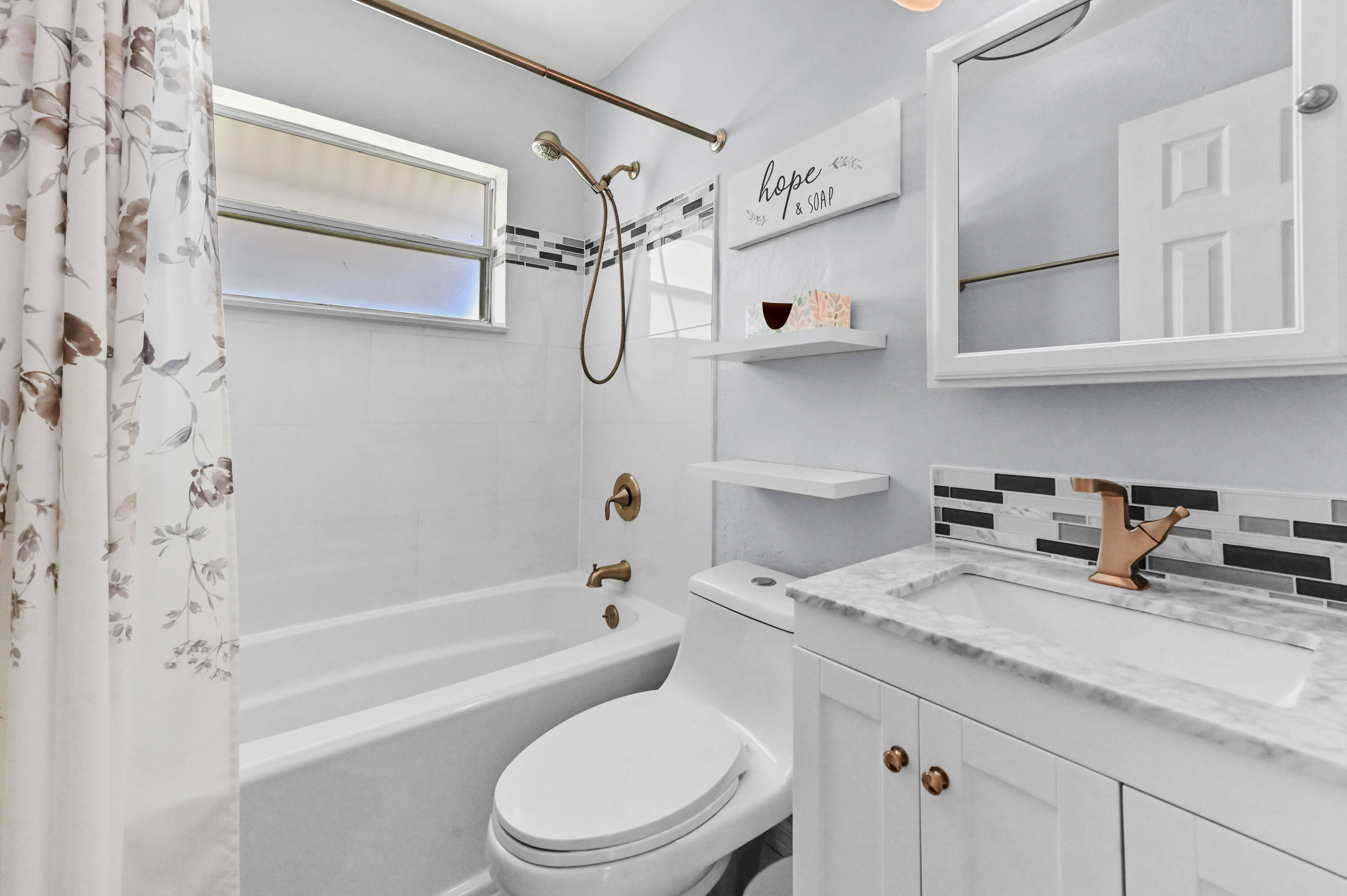 5709 Southeast Indigo Avenue Stuart, FL 34997 - Photo 21 of 26 a bathroom with a granite countertop sink a toilet and shower