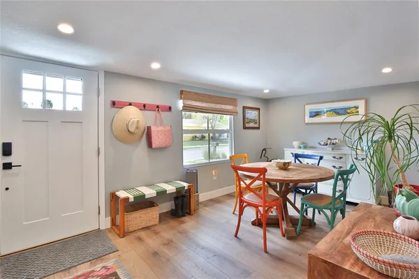 a kitchen with stainless steel appliances granite countertop a dining table chairs refrigerator and sink