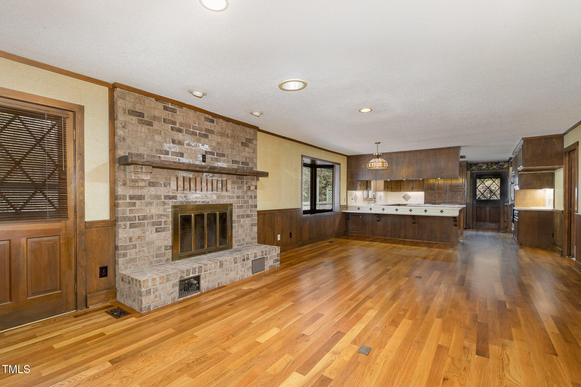 3514 Ridge Road Durham, NC 27705 - Photo 11 of 38 a view of a living room kitchen with a fireplace and wooden floor