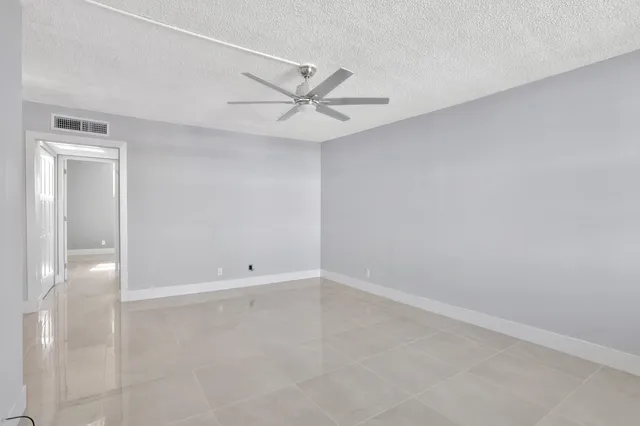 an empty room with a ceiling fan and a window
