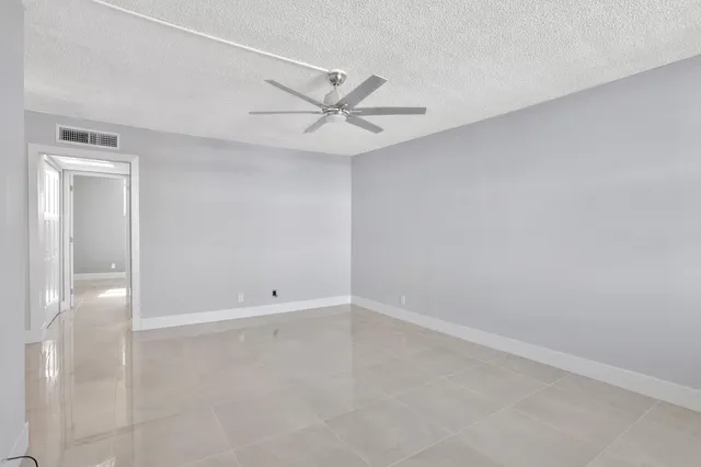 an empty room with a ceiling fan and a window
