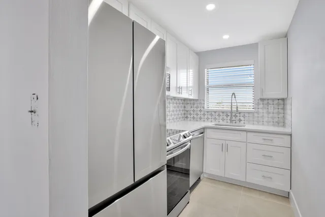 a kitchen with white cabinets and white appliances