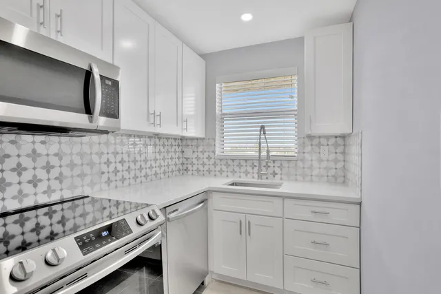 a kitchen with a sink stove and microwave