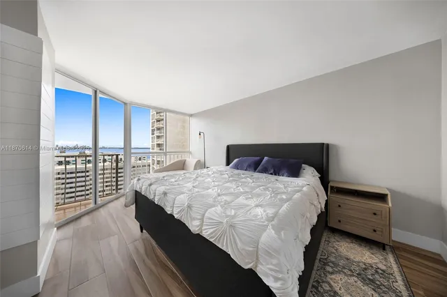 a large bedroom with a bed and a flat screen tv