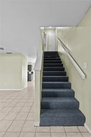 an empty room with windows and ceiling fan