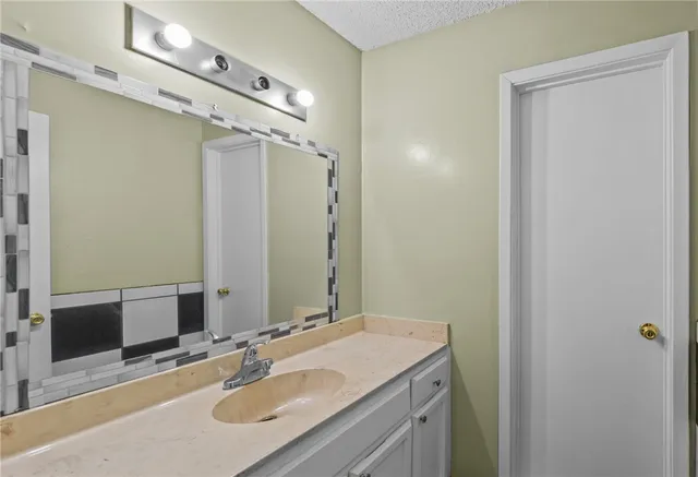 a bathroom with a granite countertop sink a toilet and shower