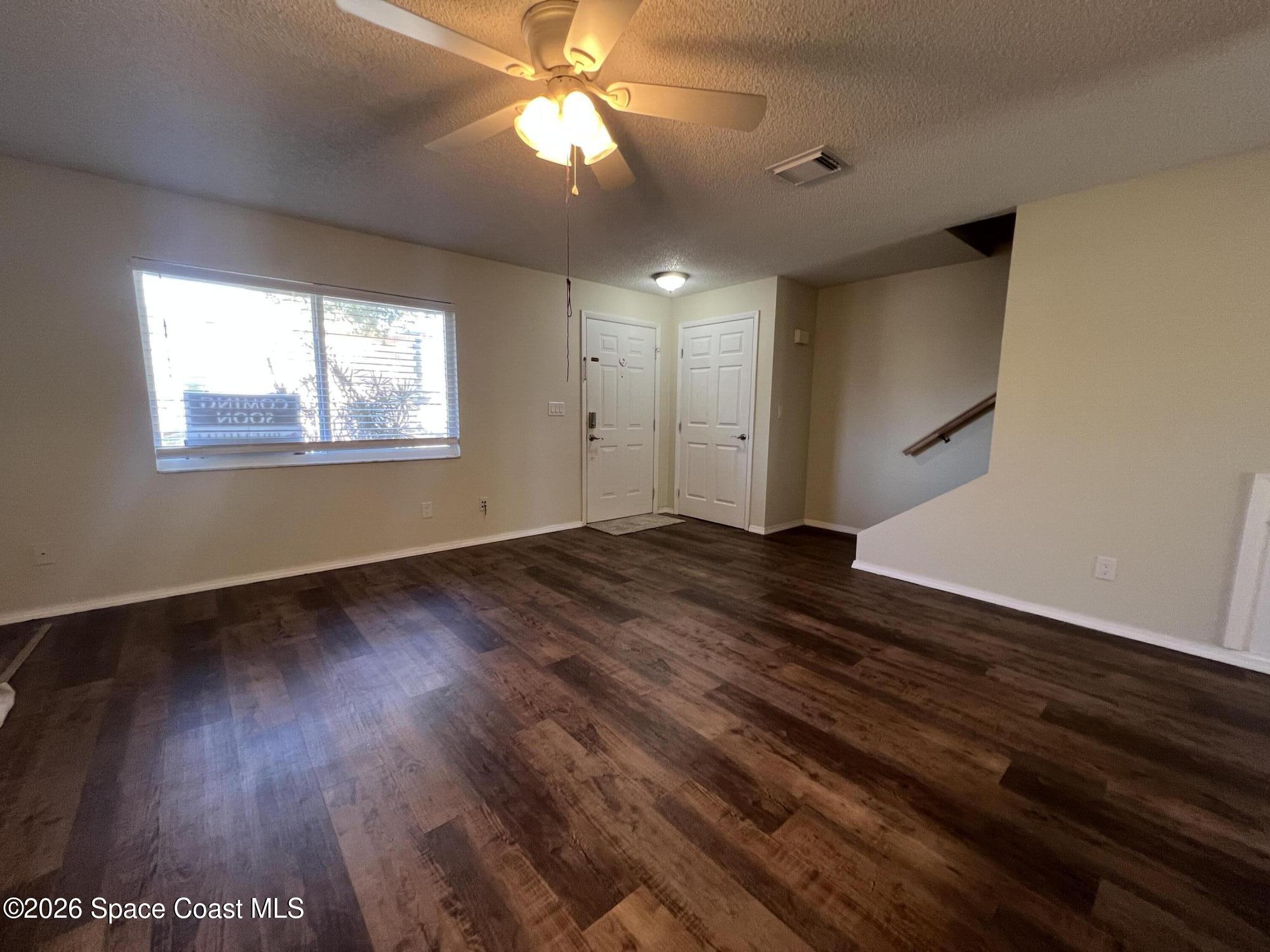 1882 Murrell Road, Unit K40 Rockledge, FL 32955 - Photo 3 of 13 an empty room with wooden floor and windows