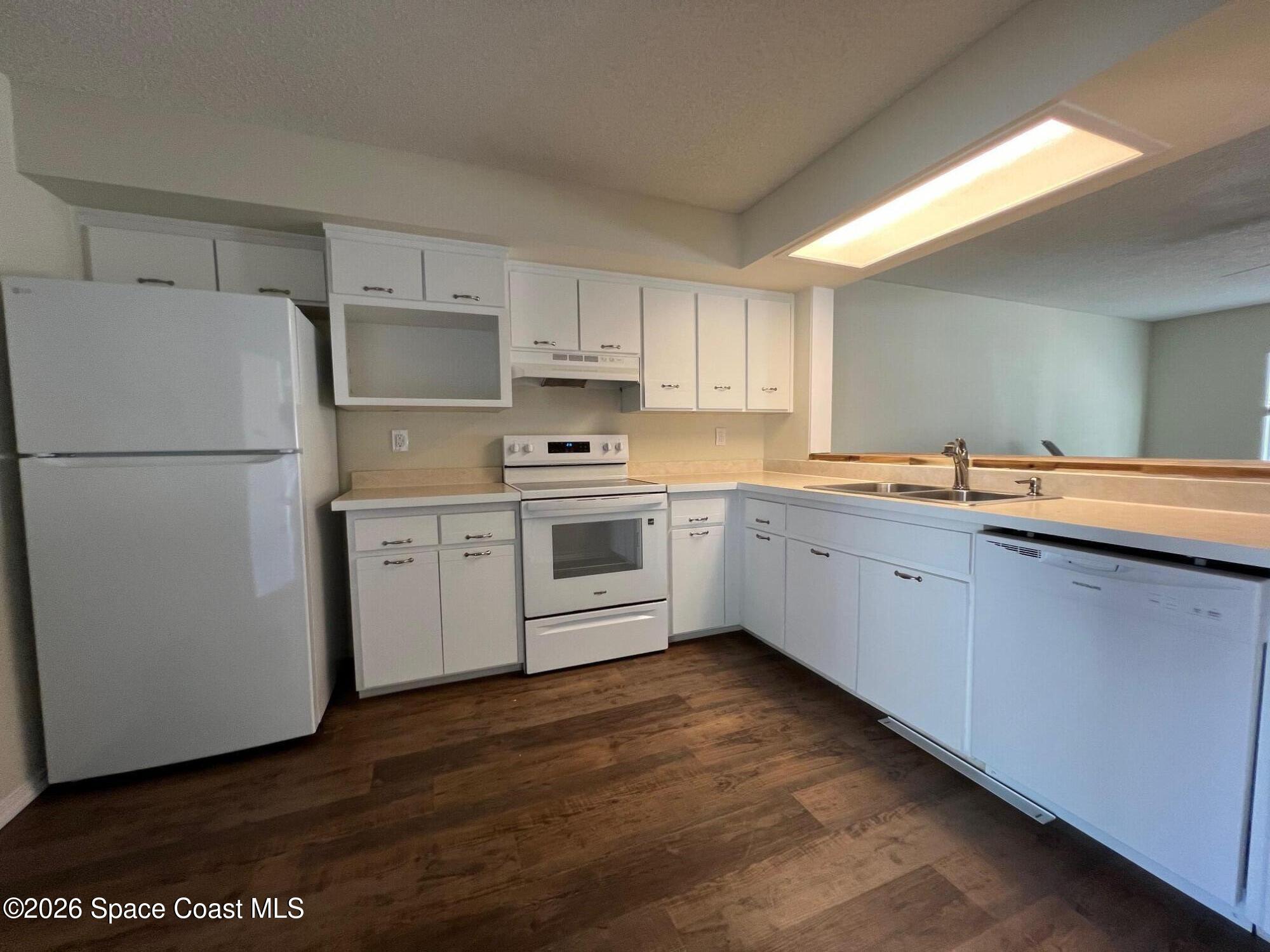1882 Murrell Road, Unit K40 Rockledge, FL 32955 - Photo 4 of 13 a kitchen with a sink a refrigerator and white cabinets