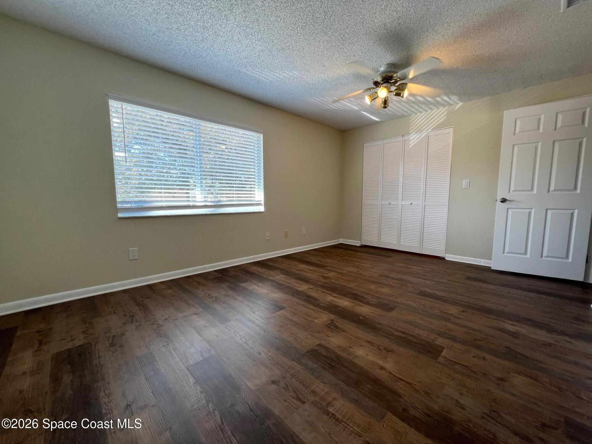 1882 Murrell Road, Unit K40 Rockledge, FL 32955 - Photo 7 of 13 a view of an empty room with wooden floor and a window