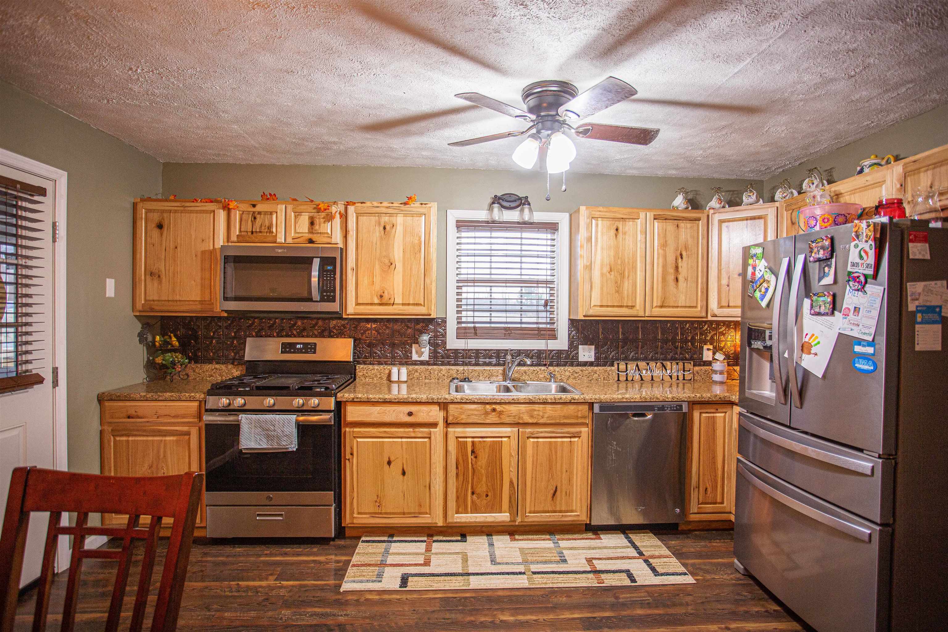 2745 Dry Hill Road West Ripley, TN 38063 - Photo 4 of 23 a kitchen with stainless steel appliances granite countertop a stove top oven a sink dishwasher and a refrigerator with wooden floor