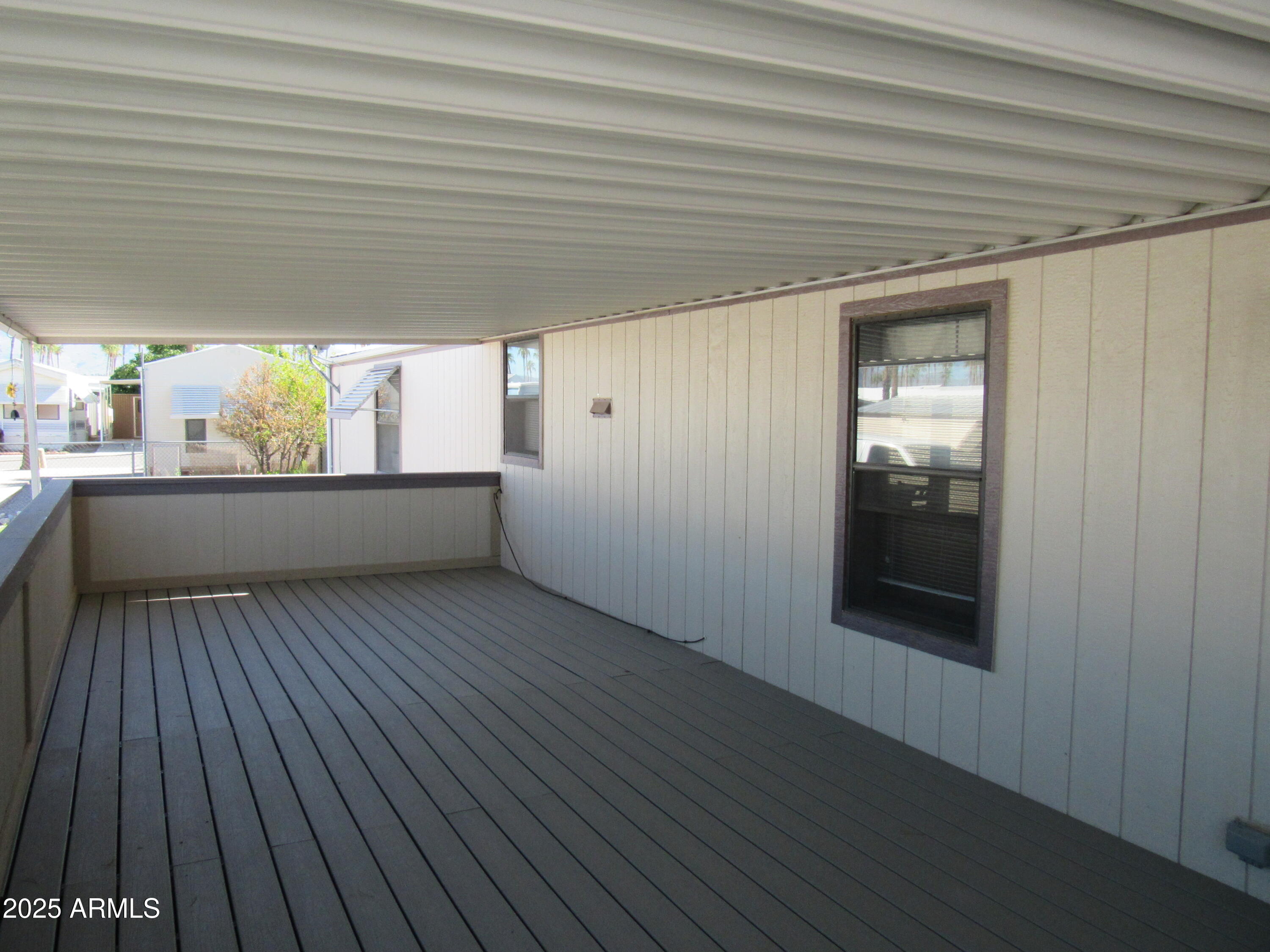 3411 South Camino Seco, Unit 107 Tucson, AZ 85730 - Photo 3 of 15 an empty room with wooden floor and windows