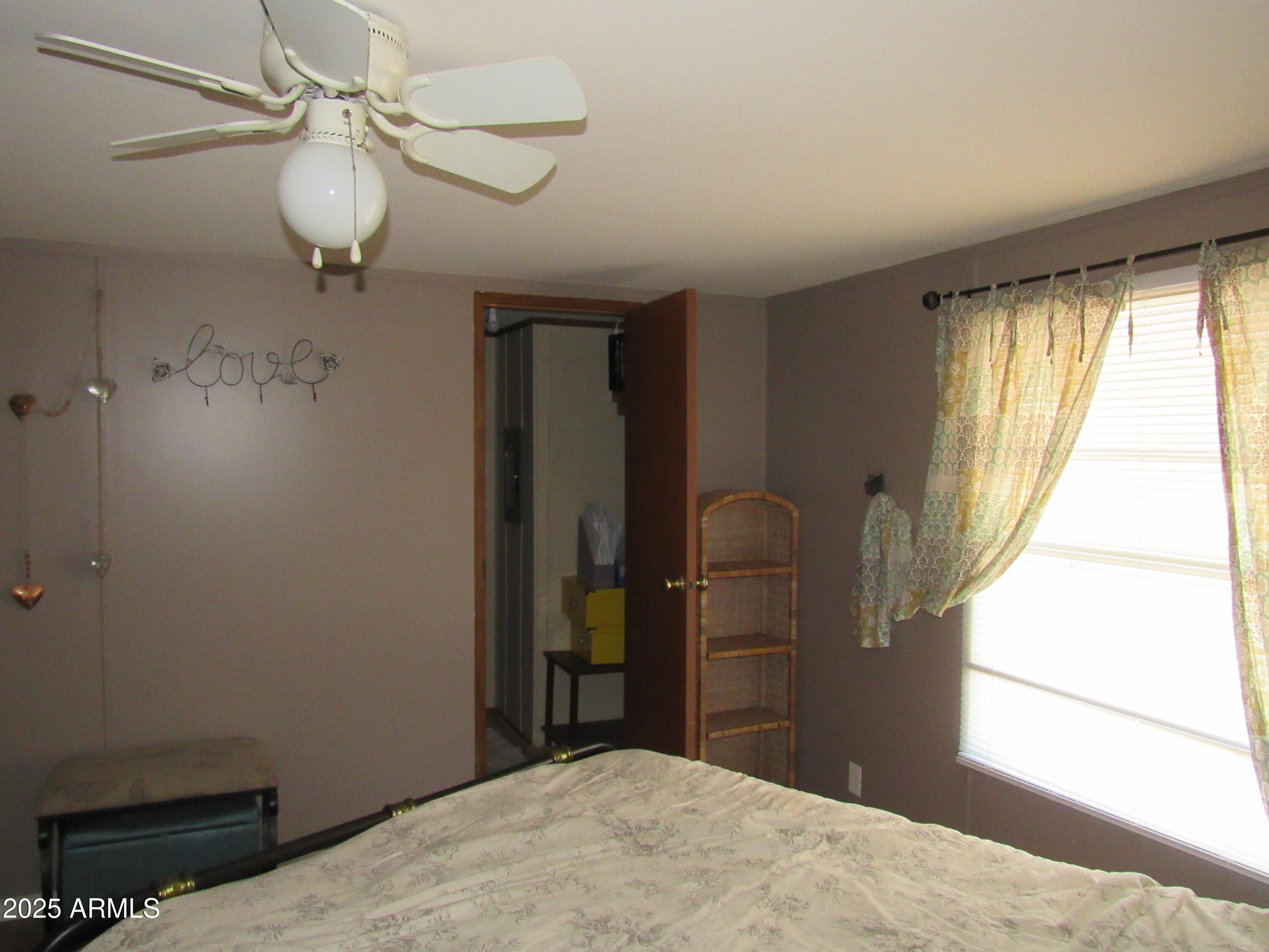 3411 South Camino Seco, Unit 107 Tucson, AZ 85730 - Photo 9 of 15 a bedroom with a bed and a chandelier