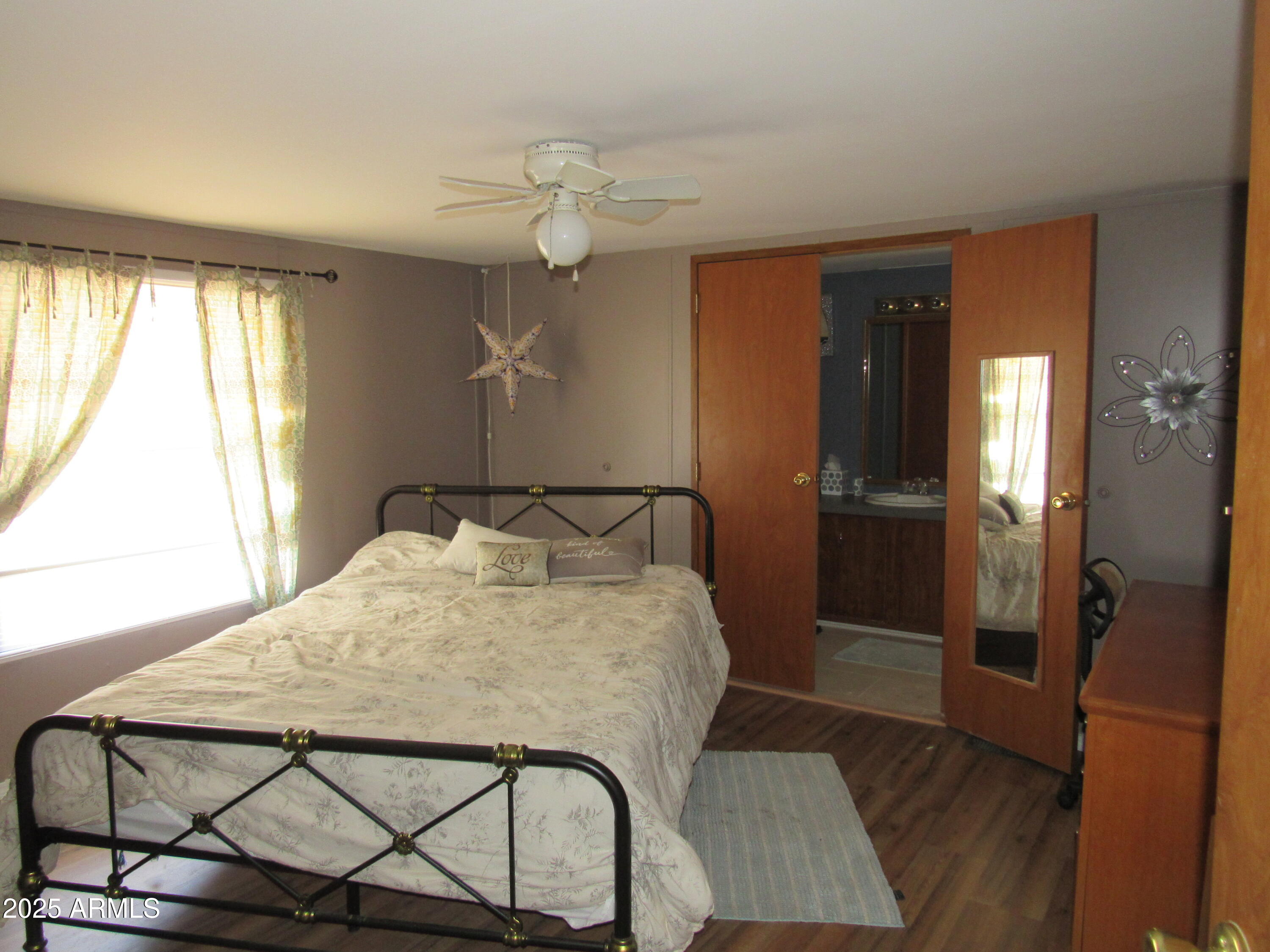 3411 South Camino Seco, Unit 107 Tucson, AZ 85730 - Photo 10 of 15 a bedroom with a bed and wooden floor