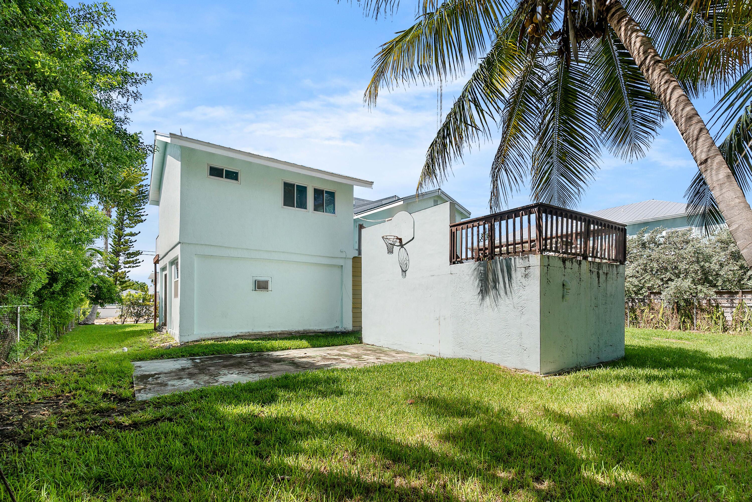 18 North Channel Drive Key Largo, FL 33037 - Photo 36 of 40 a backyard of a house with potted plants and palm trees
