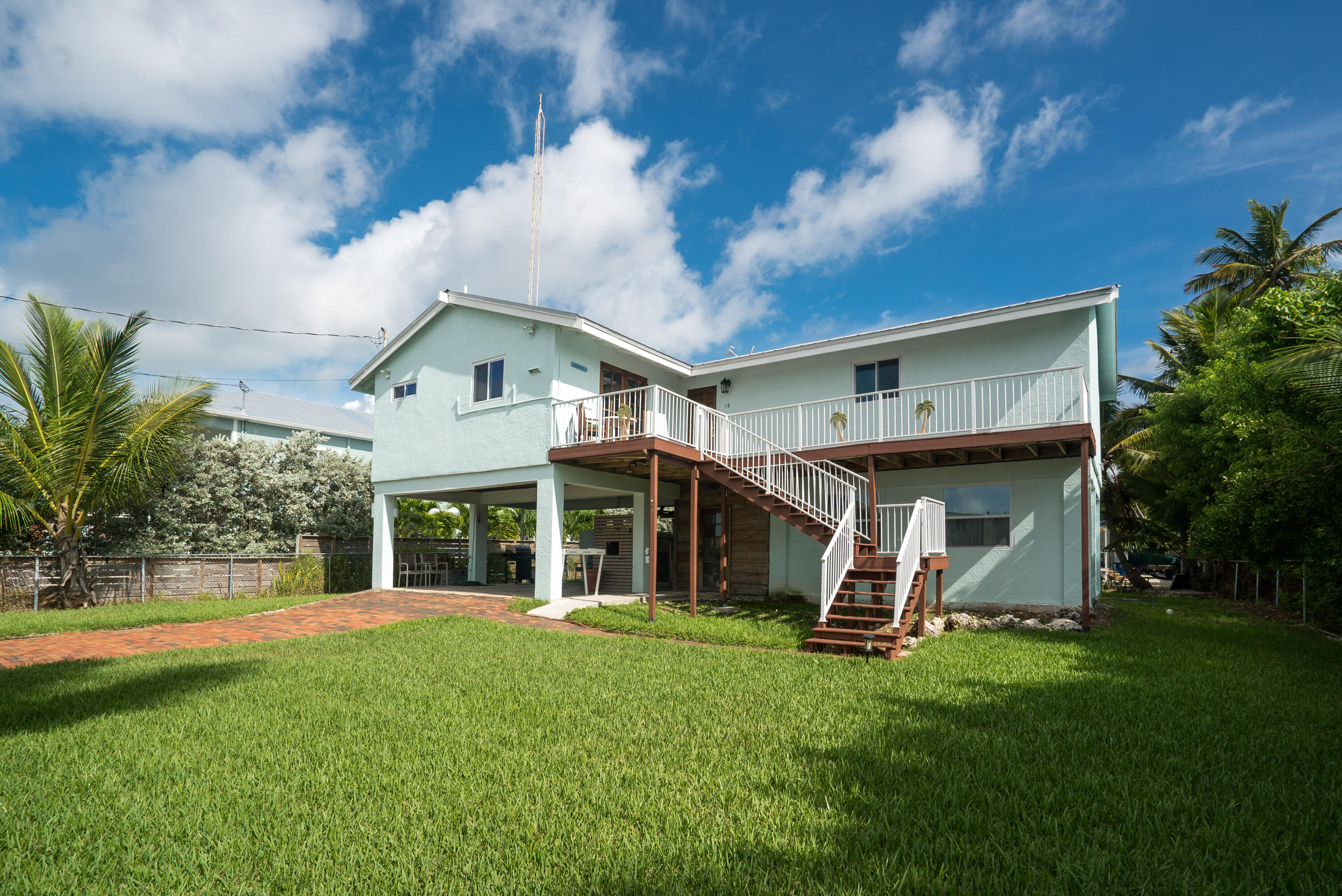 18 North Channel Drive Key Largo, FL 33037 - Photo 39 of 40 a view of a white house with a big yard and potted plants