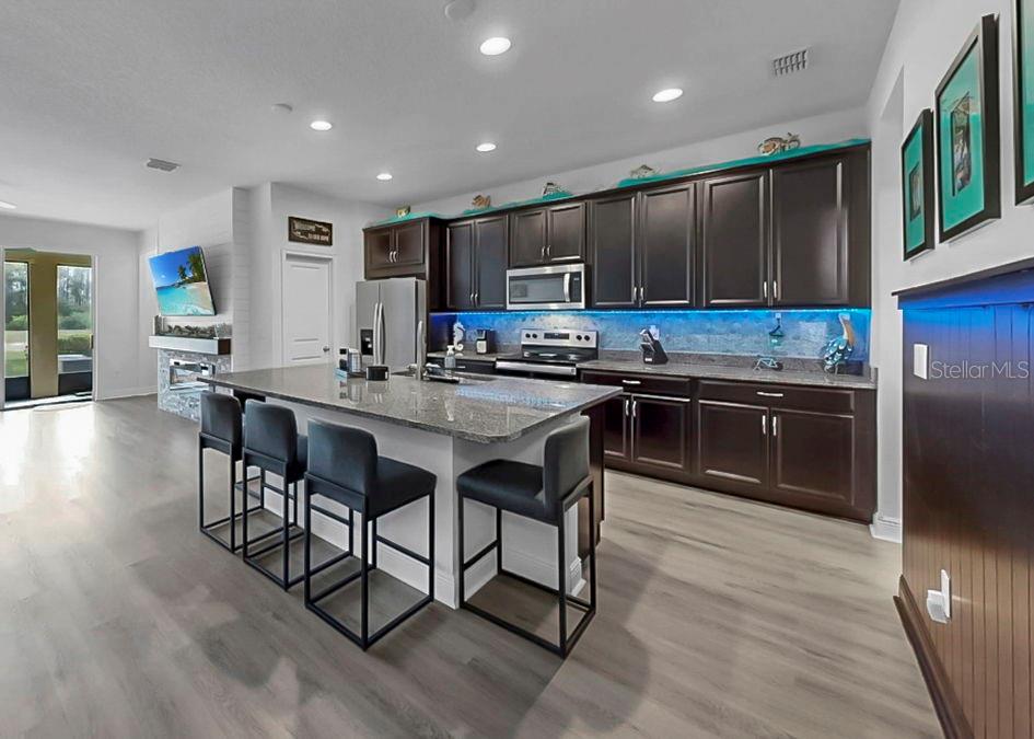 10212 Newel Valley Loop Riverview, FL 33569 - Photo 32 of 72 a kitchen with stainless steel appliances granite countertop a table chairs sink and cabinets