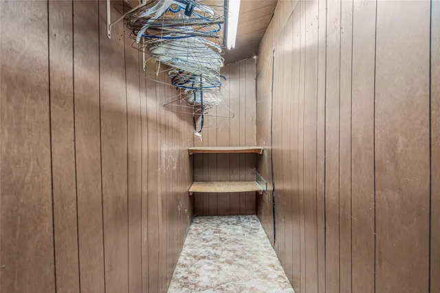 a view of an empty room with window and cabinet