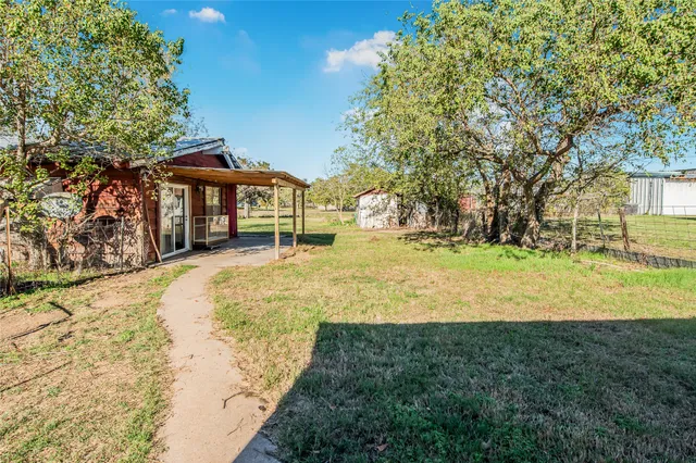 a view of a house with backyard and sitting area