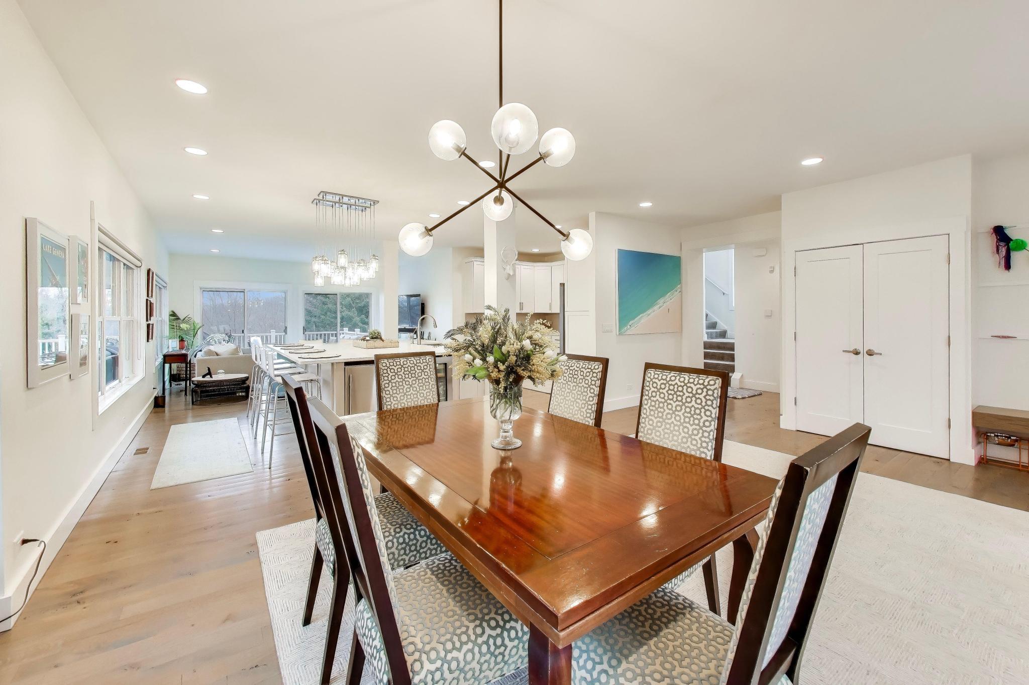 603 Agaming Road Fontana, WI 53125 - Photo 9 of 68 Bright dining area with contemporary chandelier and seamless flow into the kitchen and living spaces, perfect for gatherings.
