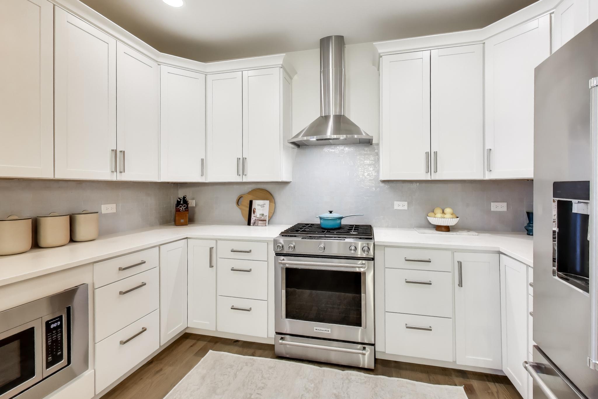 603 Agaming Road Fontana, WI 53125 - Photo 12 of 68 Well-appointed kitchen with gas range, stainless steel hood, subway tile backsplash, and ample cabinet storage.