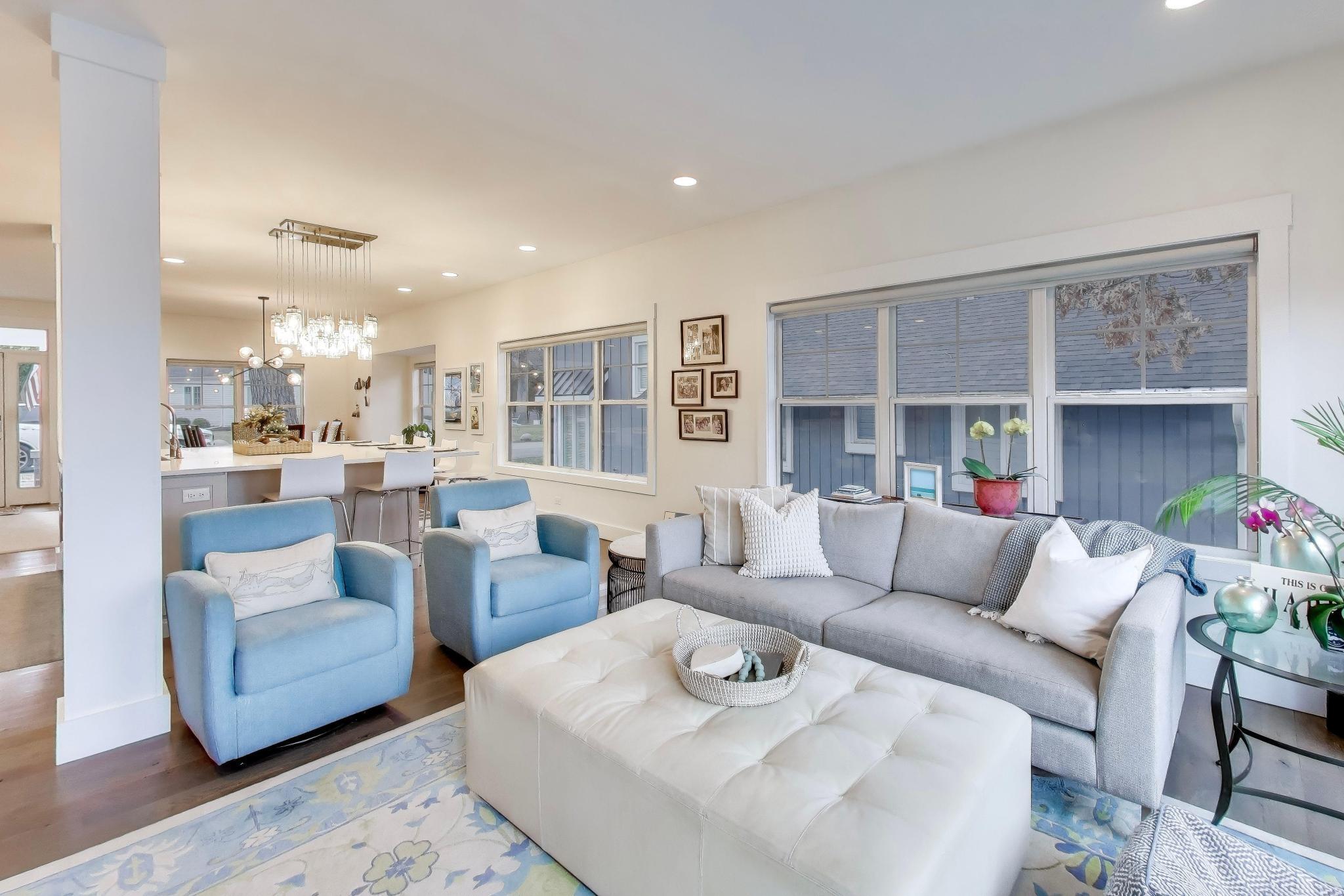 603 Agaming Road Fontana, WI 53125 - Photo 16 of 68 Open-concept main living area flowing into the kitchen and dining space, highlighted by oversized windows and contemporary lighting. An ideal layout for everyday living and entertaining.