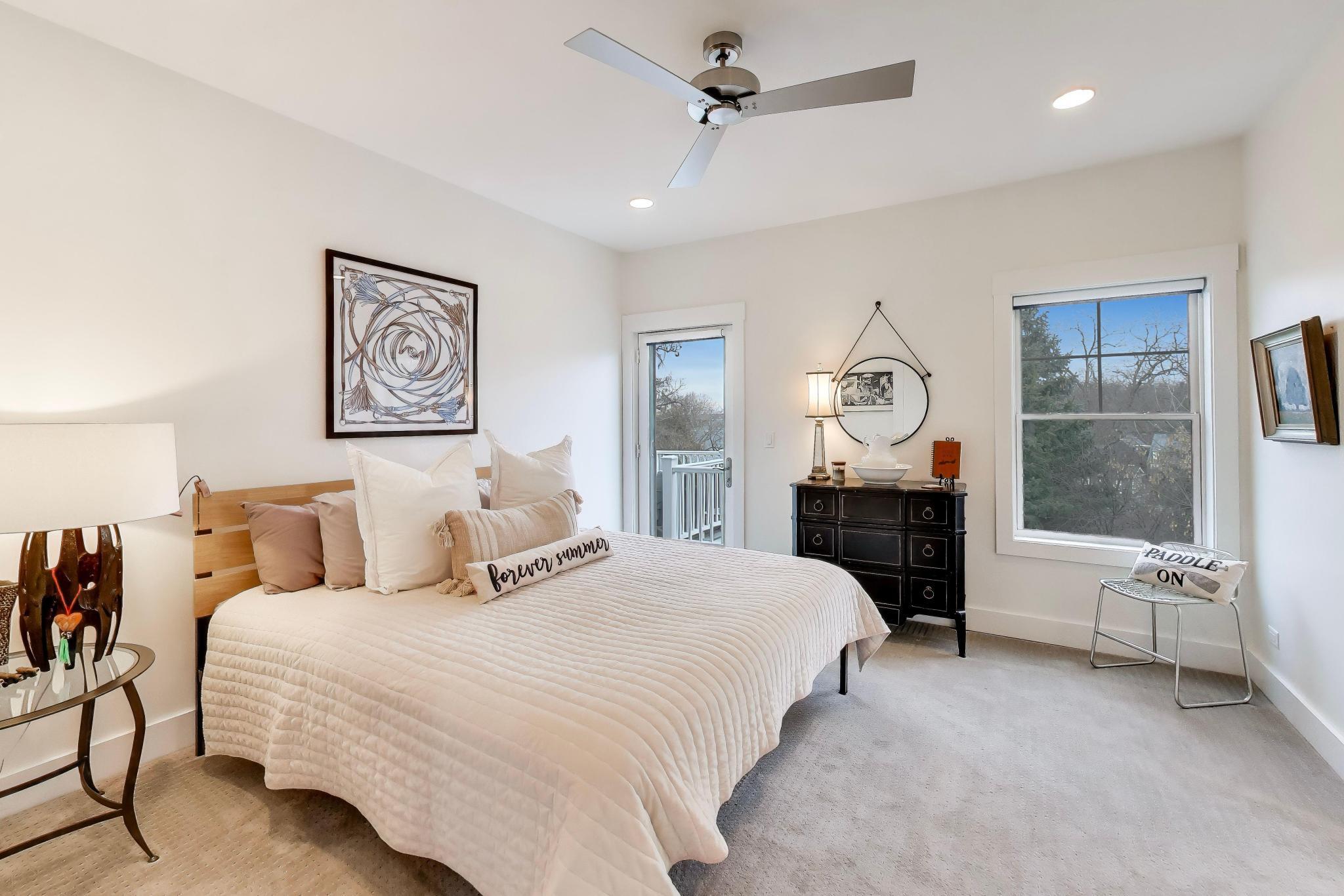 603 Agaming Road Fontana, WI 53125 - Photo 24 of 68 Generously sized main floor suite with plush carpeting, ceiling fan, and direct access to a deck. Large windows bring in natural light and enhance the tranquil atmosphere.