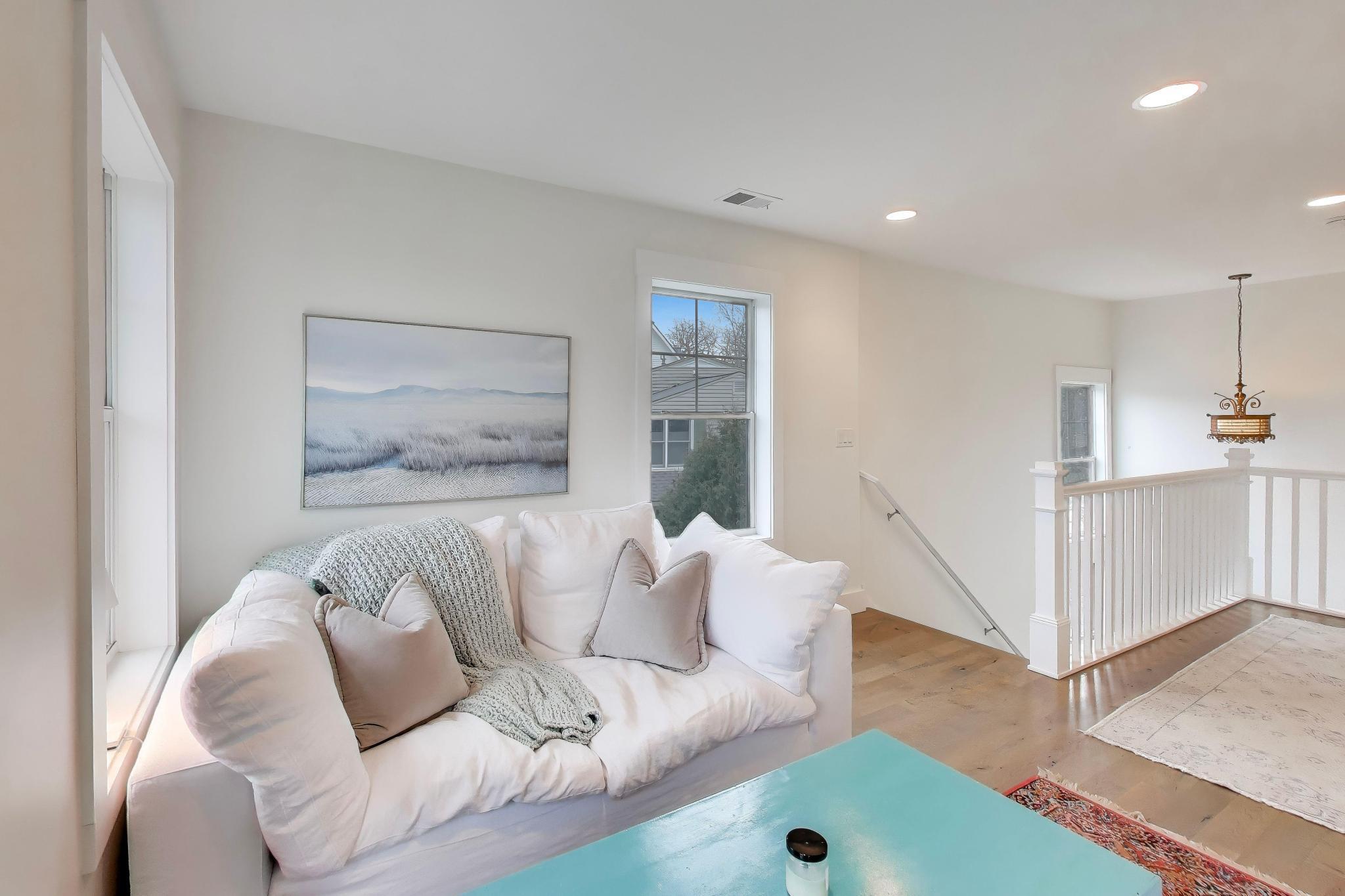 603 Agaming Road Fontana, WI 53125 - Photo 28 of 68 Light-filled loft area with hardwood flooring and railing overlook, offering flexible space for a sitting area or home office.