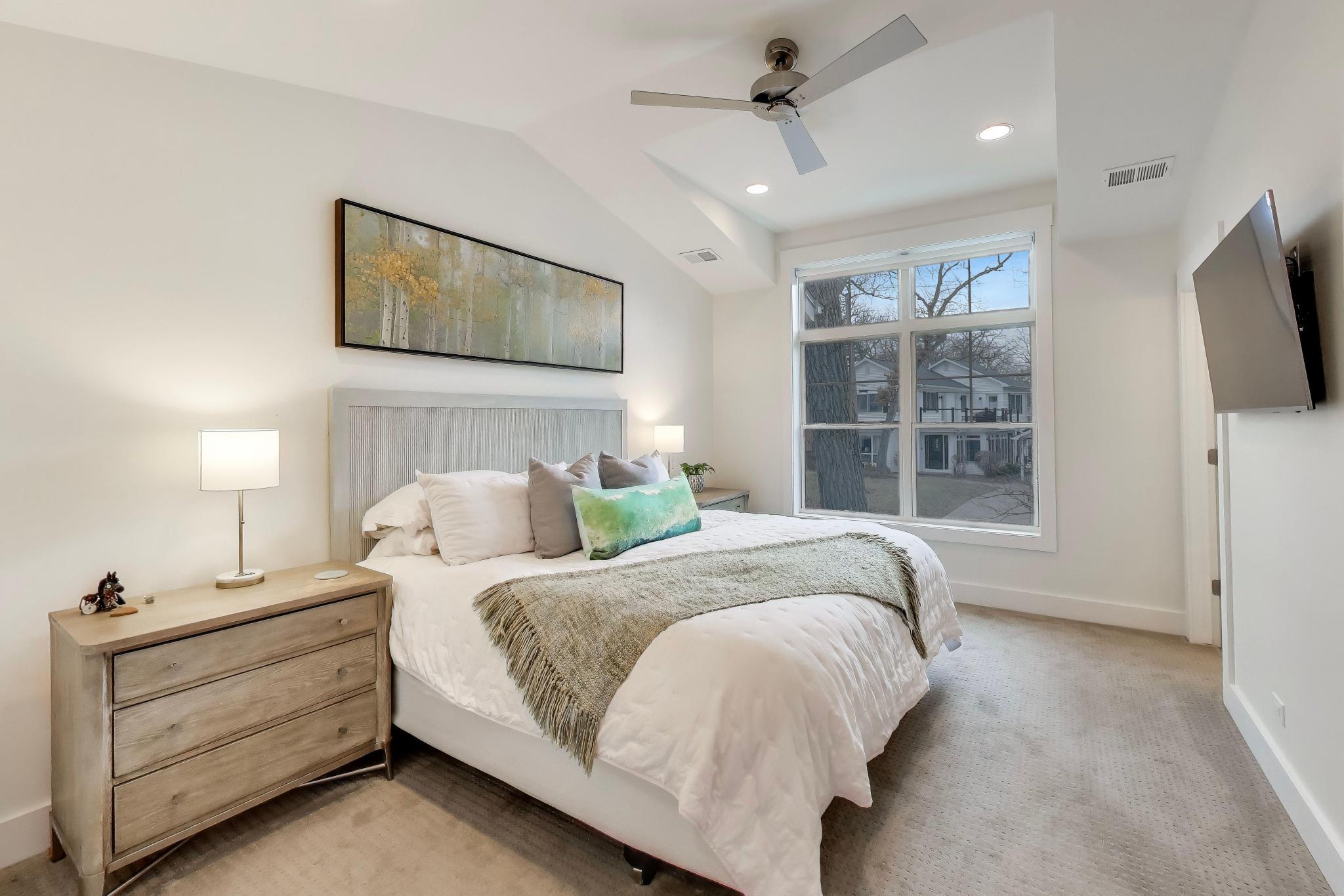 603 Agaming Road Fontana, WI 53125 - Photo 38 of 68 Comfortable guest bedroom with large windows, ceiling fan, and neutral finishes.