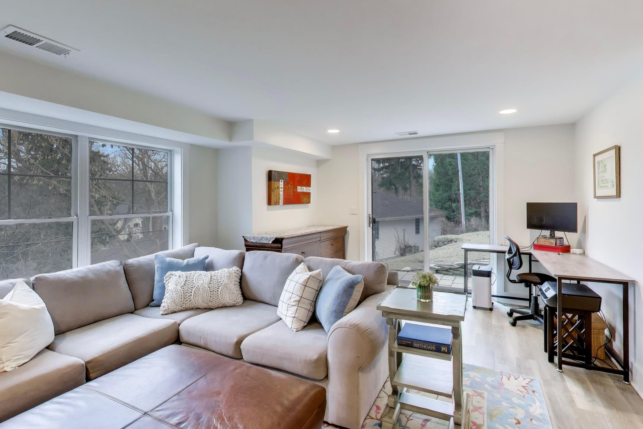 603 Agaming Road Fontana, WI 53125 - Photo 42 of 68 This versatile lower-level living space offers a comfortable seating area and dedicated workspace, with sliding glass doors that open to the backyard. Ideal for a home office, media room, or additional lounge space.