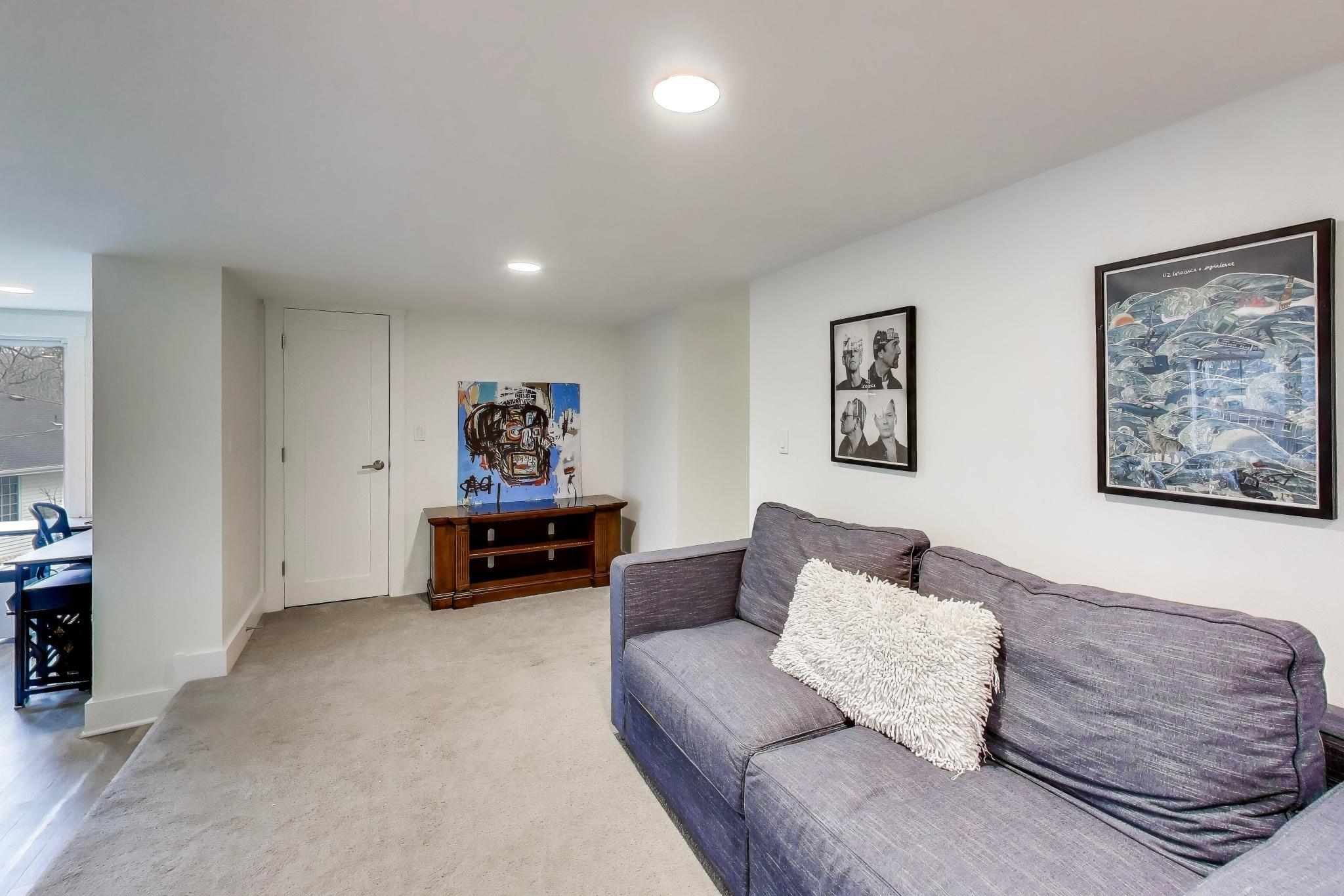 603 Agaming Road Fontana, WI 53125 - Photo 44 of 68 Additional lower-level lounge area with neutral finishes and flexible layout options, perfect for relaxing, entertaining, or creating a media space.