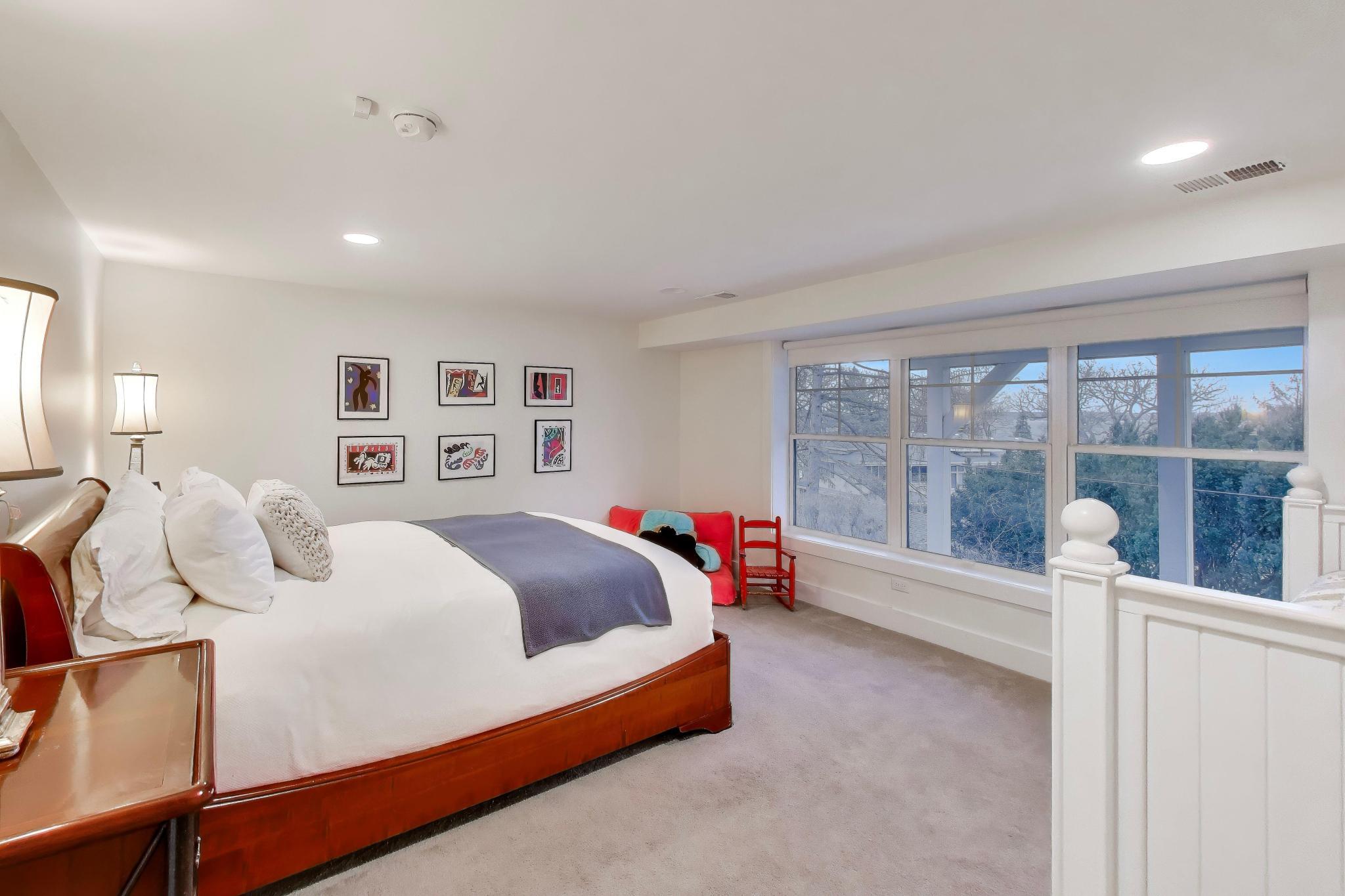 603 Agaming Road Fontana, WI 53125 - Photo 45 of 68 Spacious bedroom with plush carpeting and a wall of windows that fills the room with natural light. Neutral finishes and elevated views create a peaceful retreat.