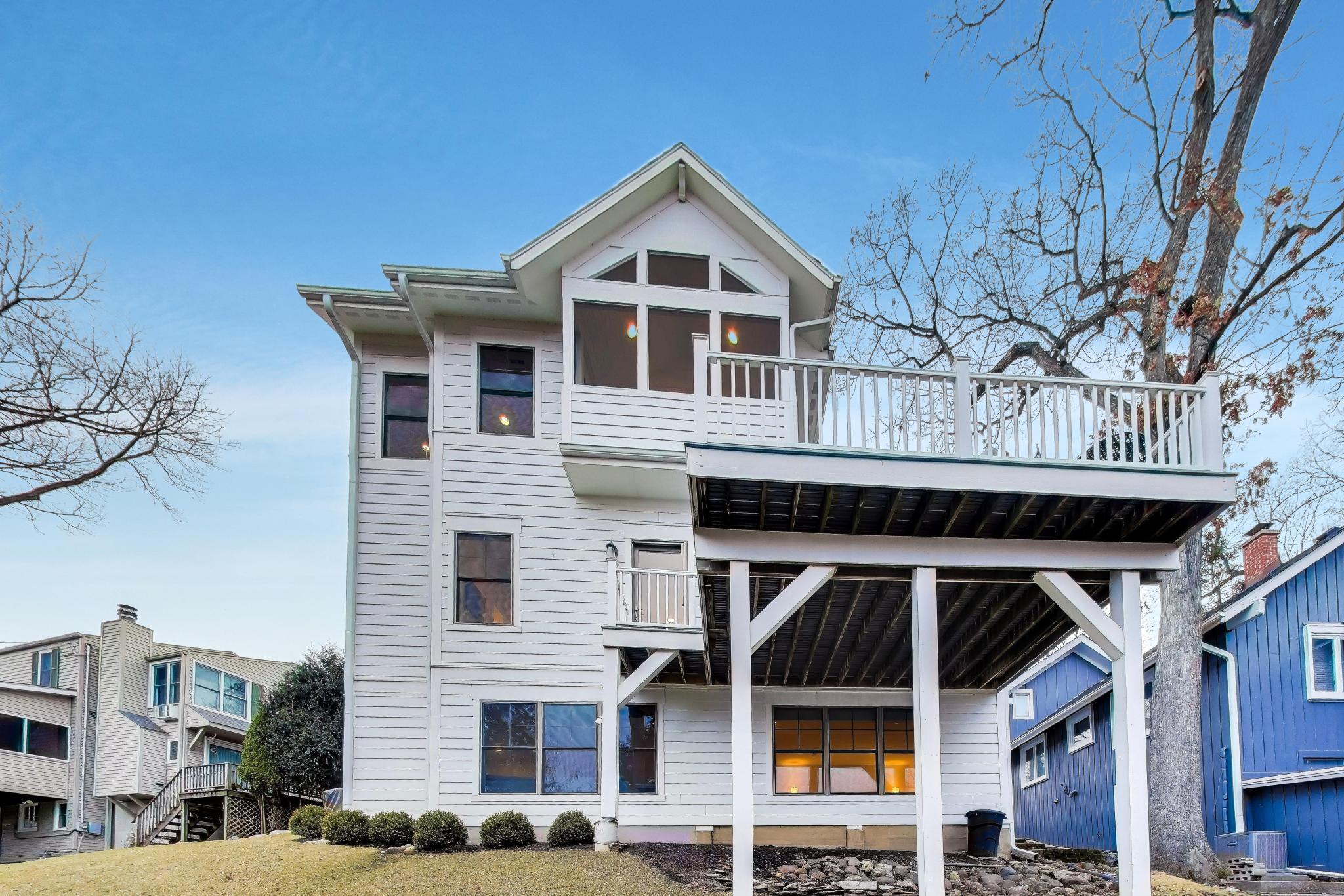 603 Agaming Road Fontana, WI 53125 - Photo 52 of 68 Striking rear elevation showcasing the upper-level deck and architectural details. Elevated design maximizes light and views.