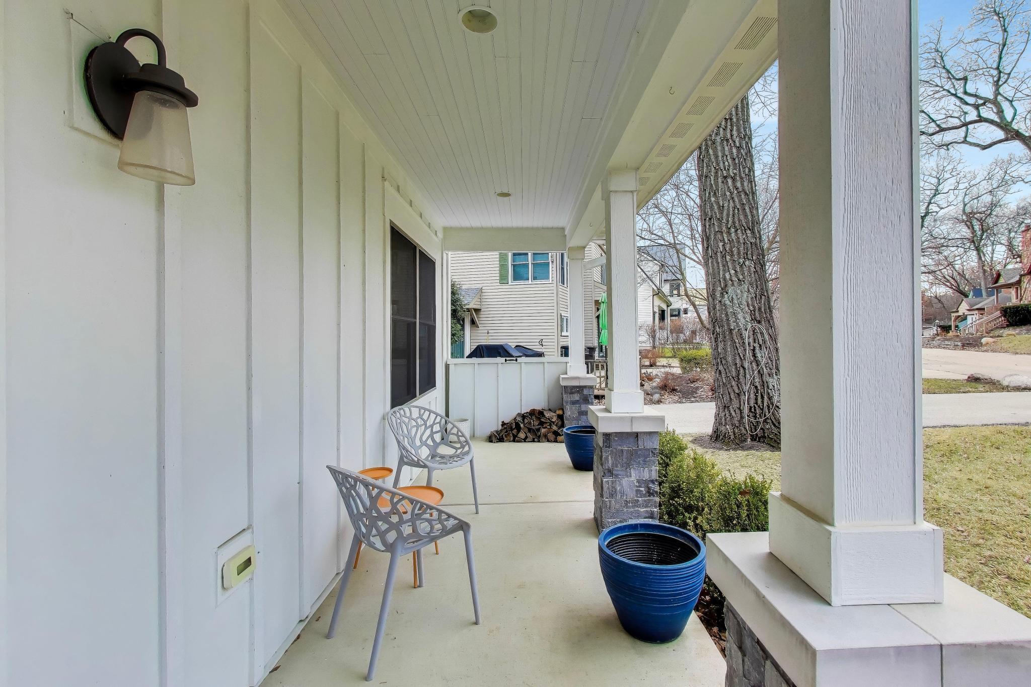 603 Agaming Road Fontana, WI 53125 - Photo 55 of 68 Cozy porch seating with space for morning coffee or evening relaxation, overlooking the front yard.