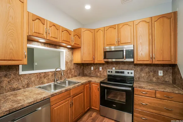 a kitchen with granite countertop a sink stove and microwave
