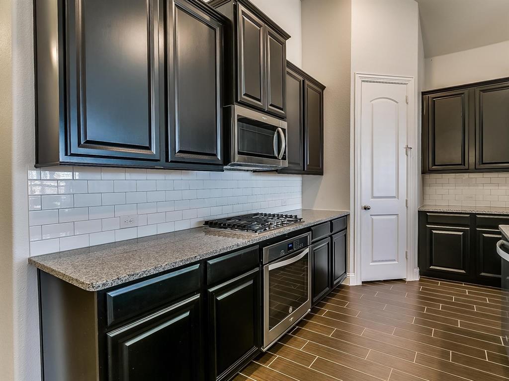 2805 Newsom Ridge Drive Mansfield, TX 76063 - Photo 11 of 33 a kitchen with granite countertop stainless steel appliances and wooden cabinets