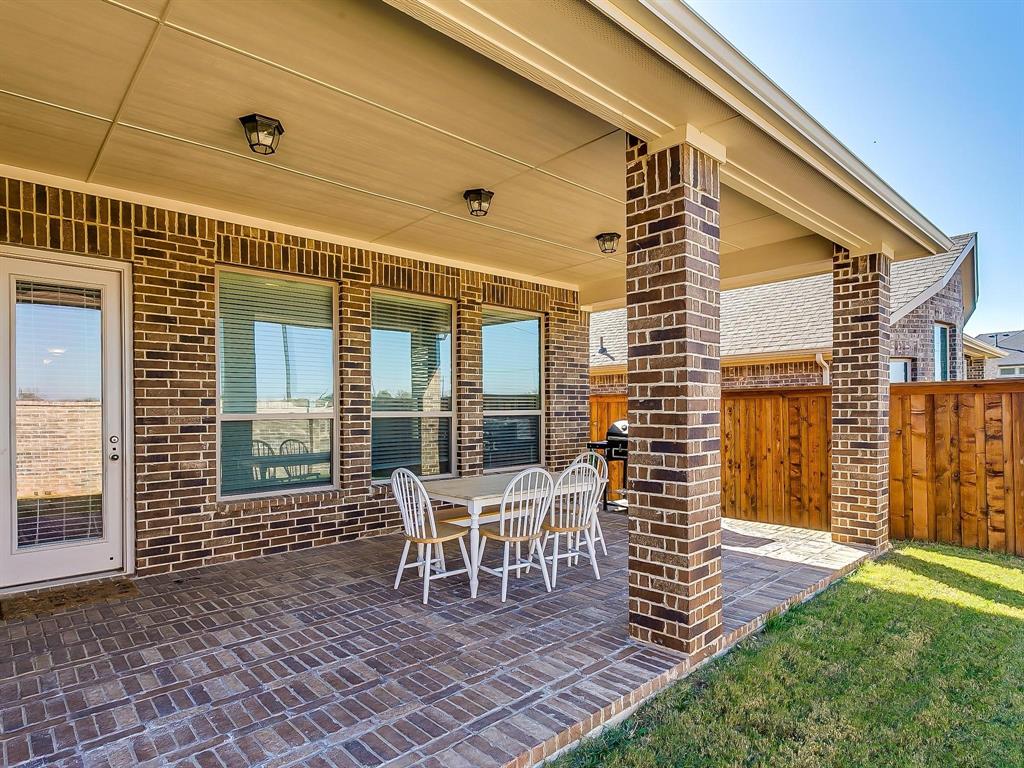 2805 Newsom Ridge Drive Mansfield, TX 76063 - Photo 29 of 33 a porch with a table and chairs and wooden floor
