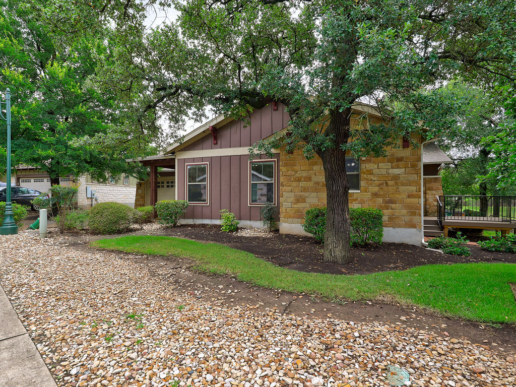 9707 Anderson Mill Road, Unit 22 Austin, TX 78750 - Photo 2 of 39 Mature trees frame this charming residence, boasting a blend of natural stone and wood siding.