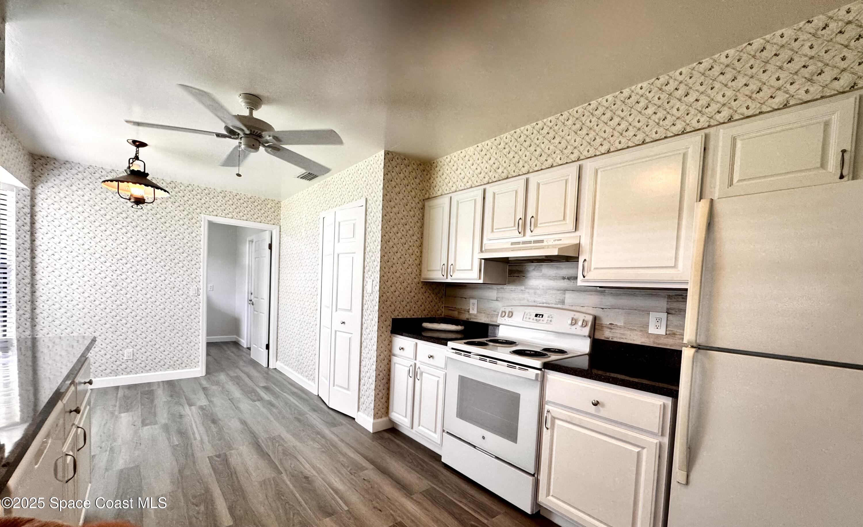 658 Ervin Street Sebastian, FL 32958 - Photo 12 of 36 a kitchen with white cabinets and white appliances