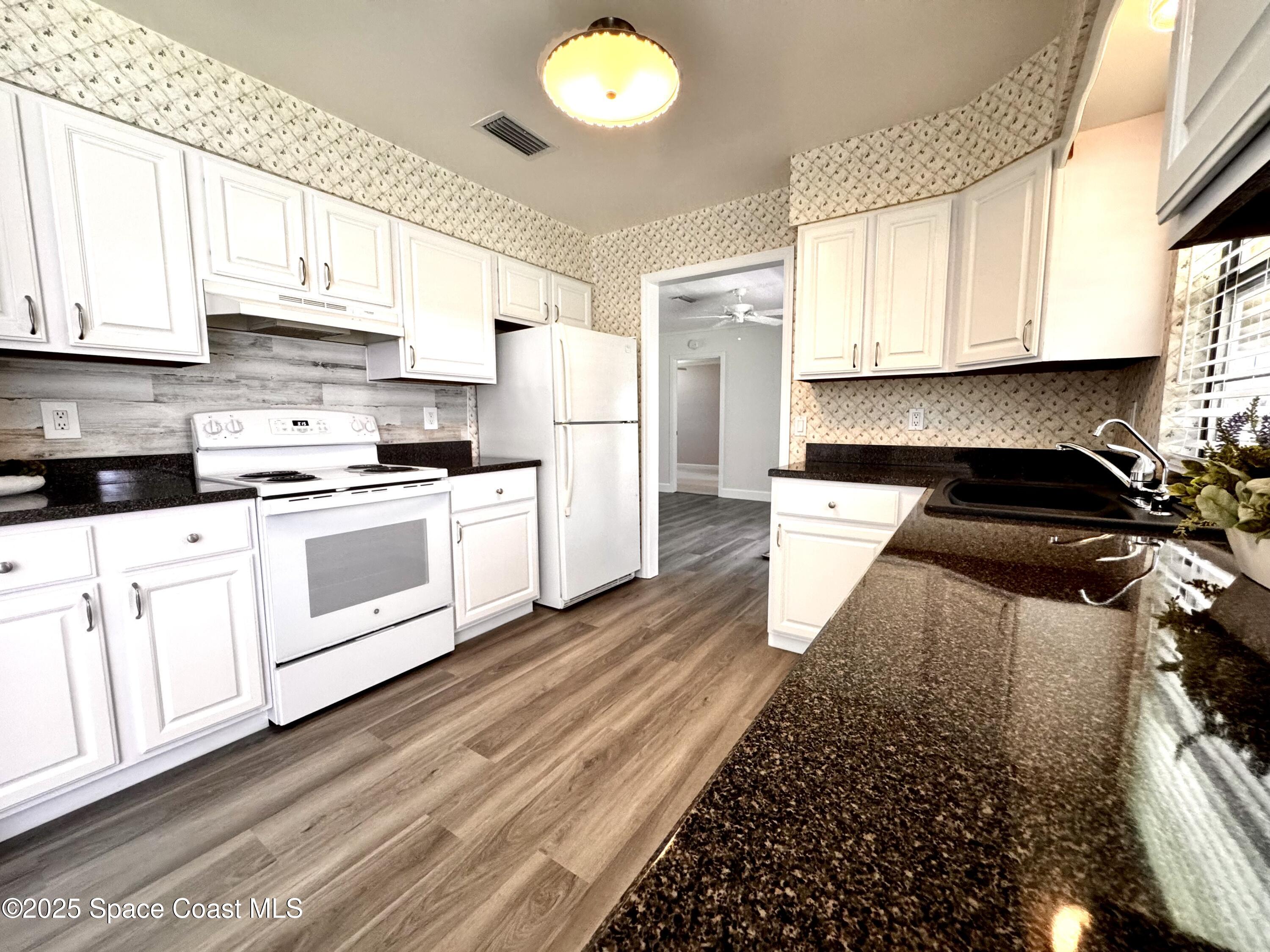 658 Ervin Street Sebastian, FL 32958 - Photo 13 of 36 a kitchen with stainless steel appliances granite countertop a stove a sink and a refrigerator