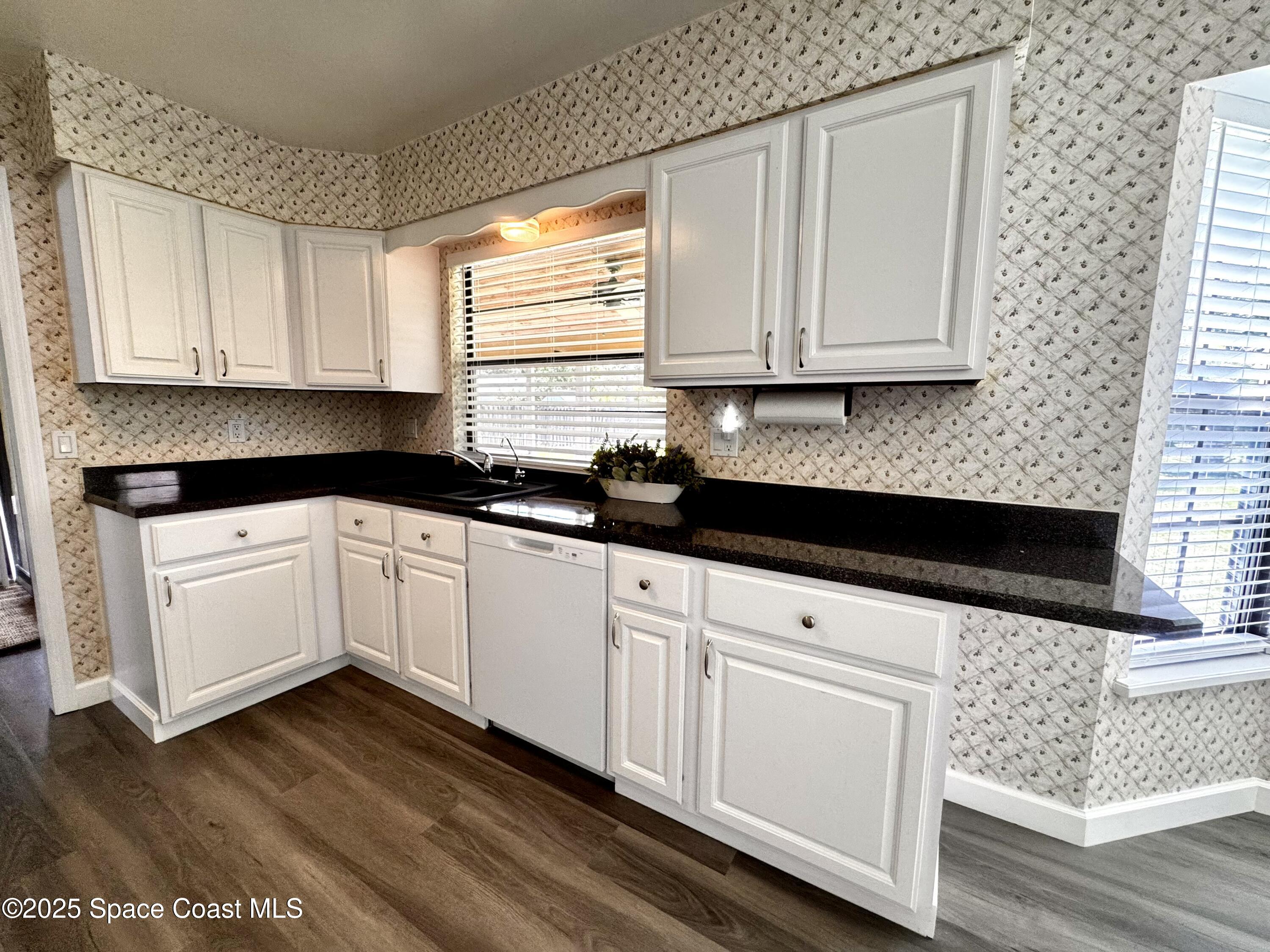 658 Ervin Street Sebastian, FL 32958 - Photo 16 of 36 a kitchen with granite countertop white cabinets and white appliances