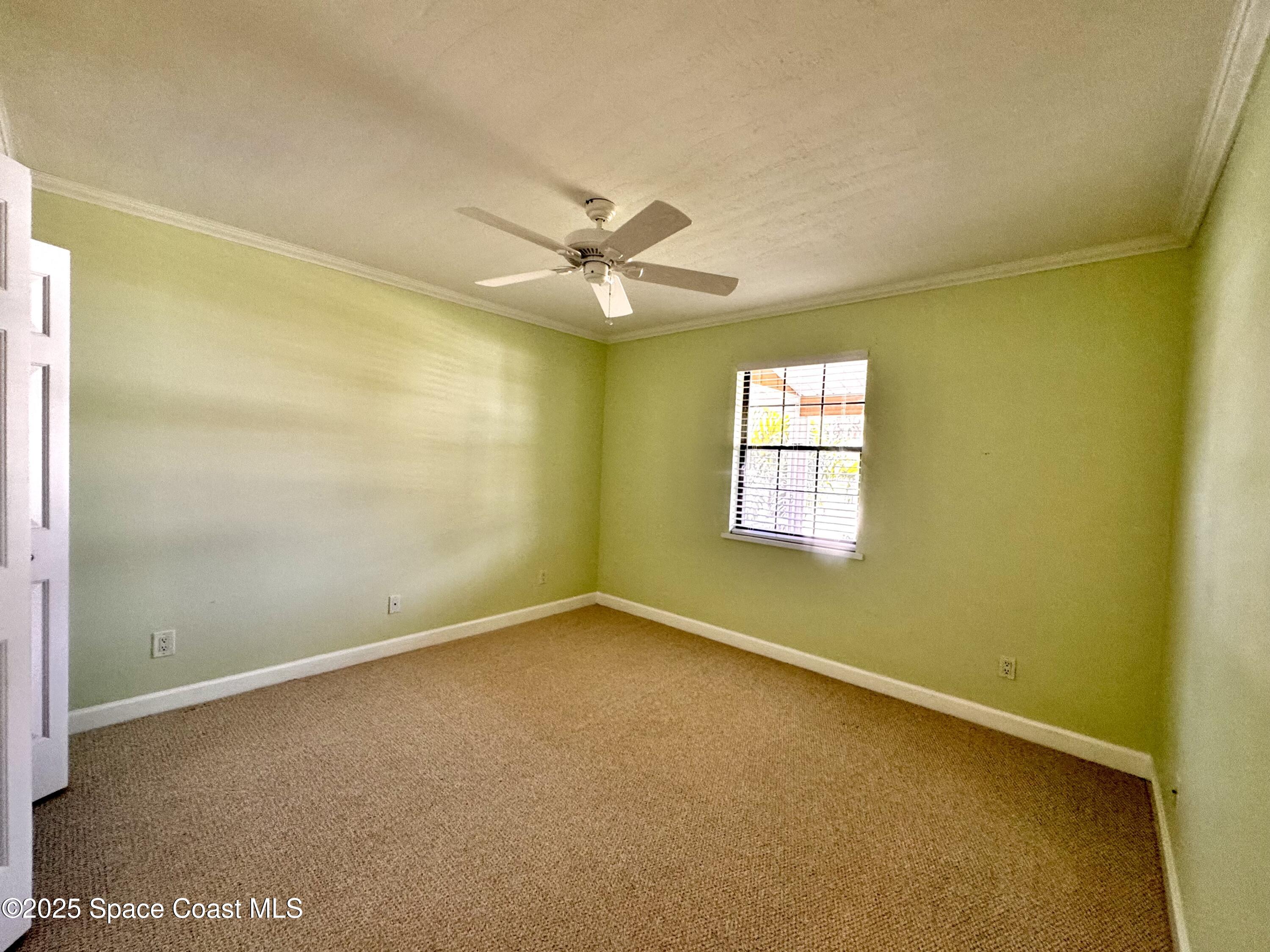 658 Ervin Street Sebastian, FL 32958 - Photo 22 of 36 an empty room with a window and a ceiling fan