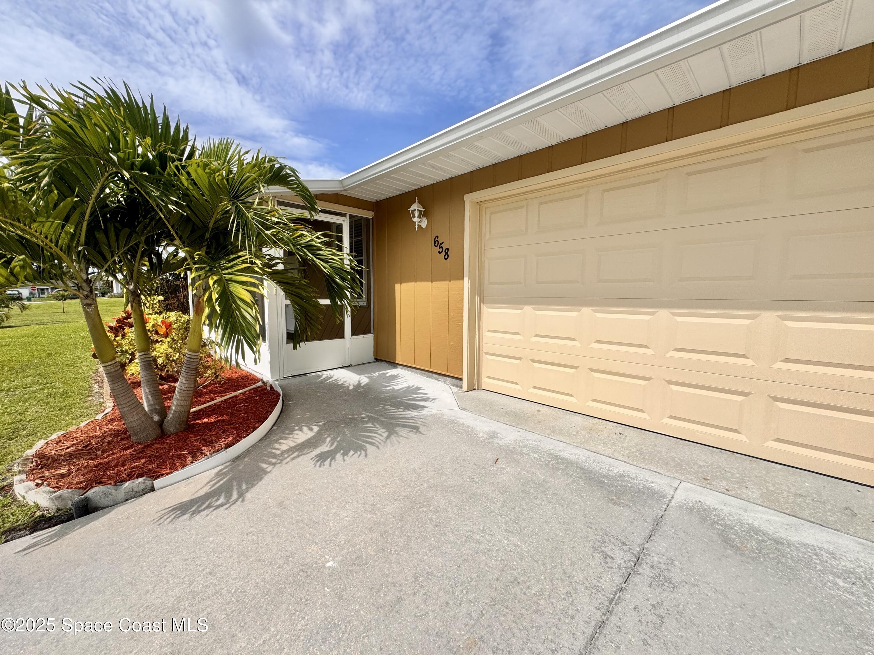 658 Ervin Street Sebastian, FL 32958 - Photo 3 of 36 a view of a backyard with plants and a garage