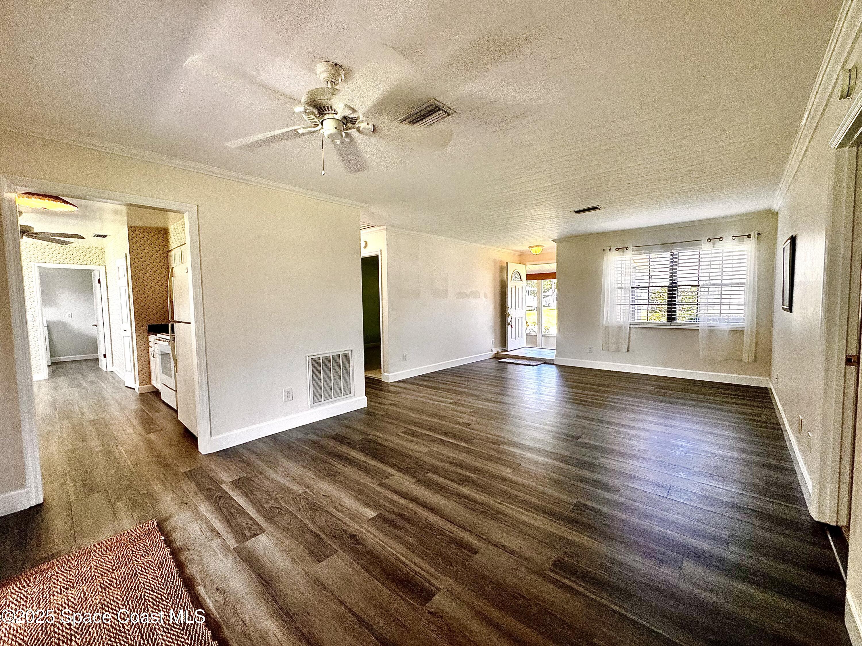 658 Ervin Street Sebastian, FL 32958 - Photo 10 of 36 a view of an empty room with window and wooden floor